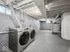 Basement laundry area featuring modern side-by-side washer and dryer and utility hookups at 1331 N Berwick Ave, Indianapolis, IN 46222