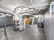 Unfinished basement featuring visible ceiling beams, utility equipment, and painted concrete floors at 1331 N Berwick Ave, Indianapolis, IN 46222