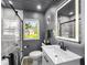 Modern bathroom with a glass-enclosed shower, vanity with a marble countertop, and a large, illuminated mirror, creating a spa-like atmosphere at 1331 N Berwick Ave, Indianapolis, IN 46222