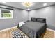 This bedroom features wood-look flooring, a patterned ceiling light, and a comfy bed with gray bedding at 1331 N Berwick Ave, Indianapolis, IN 46222