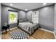 This bedroom features a gray wall, wood-look flooring, a window, and a neatly made bed with gray bedding at 1331 N Berwick Ave, Indianapolis, IN 46222