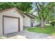 Home exterior featuring a detached garage, a paved driveway, and a well-maintained lawn at 1331 N Berwick Ave, Indianapolis, IN 46222