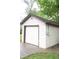 A detached, one-car garage with a white door, cream siding, and brown trim on a cloudy day at 1331 N Berwick Ave, Indianapolis, IN 46222