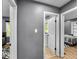 This hallway shows doorways to a bathroom and a bedroom, which features gray walls and wood-look flooring at 1331 N Berwick Ave, Indianapolis, IN 46222