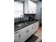 Modern kitchen features sleek white cabinets, granite countertops, and stainless steel sink and fixtures at 1331 N Berwick Ave, Indianapolis, IN 46222