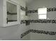 Elegant bathroom with tiled walls, window, and a shower niche for added convenience at 1352 W 22Nd St, Indianapolis, IN 46202