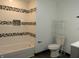Bathroom features a tub with tiled walls, updated lighting, and hardware at 1352 W 22Nd St, Indianapolis, IN 46202