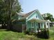 Exterior view of a two-story teal home with white trim and established landscaping at 1352 W 22Nd St, Indianapolis, IN 46202
