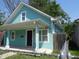 Charming blue house with a covered front porch, landscaped yard, and inviting curb appeal at 1352 W 22Nd St, Indianapolis, IN 46202