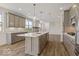 Modern kitchen boasts an island with sink, pendant lighting, and stainless steel appliances at 14878 E Keenan Cir # Lot 37, Westfield, IN 46074