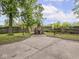 Backyard showcasing a concrete fire pit area, bordered by a wooden fence and mature trees at 1617 E 52Nd St, Indianapolis, IN 46205