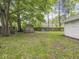 Backyard with lush green grass, mature trees, a shed, and a wooden fence for privacy at 1617 E 52Nd St, Indianapolis, IN 46205