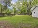 Large backyard offering ample green space, mature trees, and a wooden fence for privacy and outdoor enjoyment at 1617 E 52Nd St, Indianapolis, IN 46205