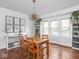 Bright dining room featuring hardwood floors, modern lighting fixture, built-in shelving, and large windows at 1617 E 52Nd St, Indianapolis, IN 46205