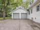 Detached two-car garage featuring gray doors, adjacent to a driveway, with a white stone exterior at 1617 E 52Nd St, Indianapolis, IN 46205