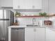 Bright kitchen featuring white cabinets, stainless steel appliances, light countertops, and open shelving with plants at 1617 E 52Nd St, Indianapolis, IN 46205