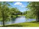 Scenic pond view with lush green trees and grassy bank on a bright sunny day with blue skies and light clouds at 17233 Gunther Blvd # 102B, Westfield, IN 46074