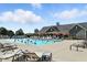 Large outdoor community pool with lounge chairs and umbrellas on a sunny day at 17233 Gunther Blvd # 102B, Westfield, IN 46074