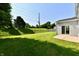 A spacious, well-maintained backyard featuring a grassy lawn, privacy fence and a sliding glass door entry at 18726 Tillamook E Run, Noblesville, IN 46062