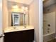 Bathroom featuring a double vanity with dark wood cabinets and a combined tub and shower at 18726 Tillamook E Run, Noblesville, IN 46062