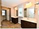 Bright bathroom features dual sinks with dark wood cabinets and tile flooring at 18726 Tillamook E Run, Noblesville, IN 46062