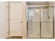 Bright bathroom featuring a glass-enclosed shower with chrome trim and two white doors at 18726 Tillamook E Run, Noblesville, IN 46062