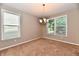 Neutral dining room with plush carpet, chandelier, and two windows at 18726 Tillamook E Run, Noblesville, IN 46062