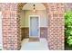 A brick arched entryway leads to a charming front door, with a hanging light and manicured landscaping at 18726 Tillamook E Run, Noblesville, IN 46062