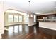 Open-concept living room with dark hardwood floors and an adjacent kitchen area at 18726 Tillamook E Run, Noblesville, IN 46062