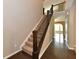 An inviting staircase with dark wood trim and beige carpeting, adjacent to warm-toned walls and floors at 18726 Tillamook E Run, Noblesville, IN 46062