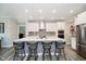 Modern kitchen island with barstool seating, stainless appliances, white cabinets, and stylish backsplash at 19581 Sumrall Pl, Westfield, IN 46074