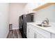 Modern laundry room featuring a front-load washer and dryer, sink, and white cabinets for storage at 19581 Sumrall Pl, Westfield, IN 46074