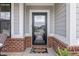 Close-up of the stylish front door with brick accents, a welcome mat, and fresh plants, adding a touch of charm at 2223 Ryder Pl, Westfield, IN 46074