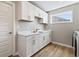 This spacious laundry room features ample white cabinets and counter space, plus modern appliances at 2223 Ryder Pl, Westfield, IN 46074
