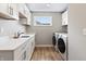 This is a bright laundry room with white cabinets and modern appliances at 2223 Ryder Pl, Westfield, IN 46074