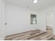 Bright bedroom with hardwood floors, a window, and a view into the ensuite bathroom at 233 N Devon Ave, Indianapolis, IN 46219