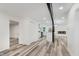 Open-concept living space with modern flooring, white walls, and a view into the kitchen at 233 N Devon Ave, Indianapolis, IN 46219