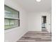 Sunlit room with wood flooring and a large window, seamlessly connecting indoor and outdoor spaces at 233 N Devon Ave, Indianapolis, IN 46219