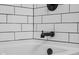 A close up of a tub featuring a black faucet against white tiled walls at 2645 Washington St, Columbus, IN 47201
