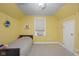 Cozy bedroom with light-yellow walls and carpet featuring a single bed and bright natural light at 2645 Washington St, Columbus, IN 47201