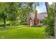 Quaint brick home with a lush green lawn and mature trees on a sunny day at 2645 Washington St, Columbus, IN 47201