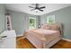 Comfortable bedroom with neutral tones, a large window, and hardwood floors at 2645 Washington St, Columbus, IN 47201