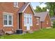 Brick home's rear exterior features a cozy sunroom entrance and a well-maintained lawn at 2645 Washington St, Columbus, IN 47201