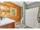 Charming bathroom featuring wood paneling, a window and a floral shower curtain at 2780 W Grizzly Trl, Martinsville, IN 46151