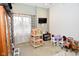 bedroom area with a dollhouse, play table, TV, and large window at 2780 W Grizzly Trl, Martinsville, IN 46151