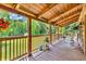 Covered deck features wood flooring, seating, and beautiful views of the surrounding trees at 2780 W Grizzly Trl, Martinsville, IN 46151