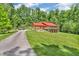 Charming log home with red roof, spacious driveway, and lush green lawn surrounded by mature trees at 2780 W Grizzly Trl, Martinsville, IN 46151