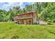 Beautiful two-story log home featuring multiple decks, surrounded by a lush green lawn and mature trees at 2780 W Grizzly Trl, Martinsville, IN 46151