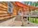 Charming log home showcasing a welcoming entrance with a small porch and well-maintained landscaping at 2780 W Grizzly Trl, Martinsville, IN 46151