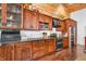 Kitchen with dark wood cabinets, black countertops, and stainless steel appliances at 2780 W Grizzly Trl, Martinsville, IN 46151